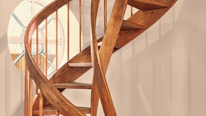 A wooden spiral staircase with a circular landing area. - Outsite Chelsea - Work, Connect, Explore (New York)