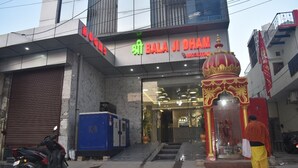 A building with a sign for "Shri Bala Ji Dam" and a small shrine with a red and gold dome. - Shri Balaji Dham Hotel (Vrindavan)