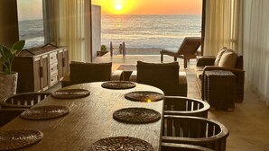 A dining area with a view of the sunset over the ocean, a ceiling fan, and a large flat-screen TV on the wall. - Nine bedroom  in Mexico, Litibú (Litibú)