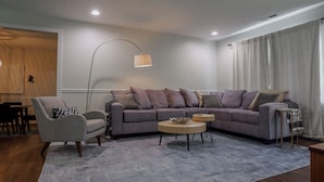 A modern living room with a grey sofa, a round coffee table, and a floor lamp.