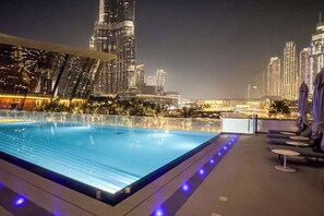 Une piscine sur le toit offrant une vue panoramique sur la ville, avec notamment un gratte-ciel bien visible.