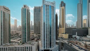 A high-rise building with a modern design, surrounded by other tall buildings in a cityscape. - Studio with City Views & Modern Amenities in MAG 318, Business Bay (Business Bay)