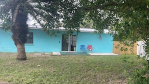A house with a blue exterior, a front door, and two folding chairs outside. - 1 block to the beach, perfect! (Cocoa Beach)