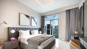 Ein modernes Hotelzimmer mit einem großen Bett, einem Schreibtisch und Blick auf die Stadt.