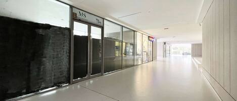 A corridor with glass doors, a sign for 'MS Real Estate', and a 'Yougo' sign.