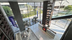 A modern interior with large windows, a marble coffee table, and a staircase with a railing.