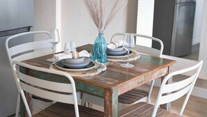 A dining table set with plates, glasses, and a vase.