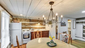 A kitchen with a wooden wall, a chandelier, a dining table with chairs, and a refrigerator. - Georgetown Home Near Kentucky Horse Park! (Georgetown)