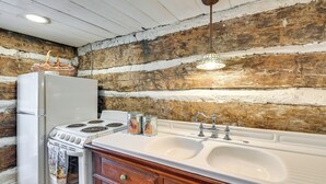 A kitchen with a white stove, refrigerator, and sink. There are two jars on the counter. - Georgetown Home Near Kentucky Horse Park! (Georgetown)