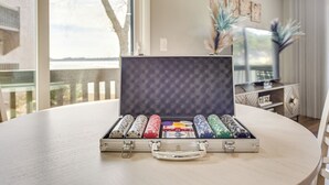 A poker set in a case on a table with a view of a building and a tree outside. - Pinehurst Lake Condo: Water View & Community Perks (Pinehurst)