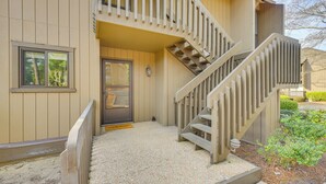 A two-story building with a wooden staircase and a door. - Pinehurst Lake Condo: Water View & Community Perks (Pinehurst)