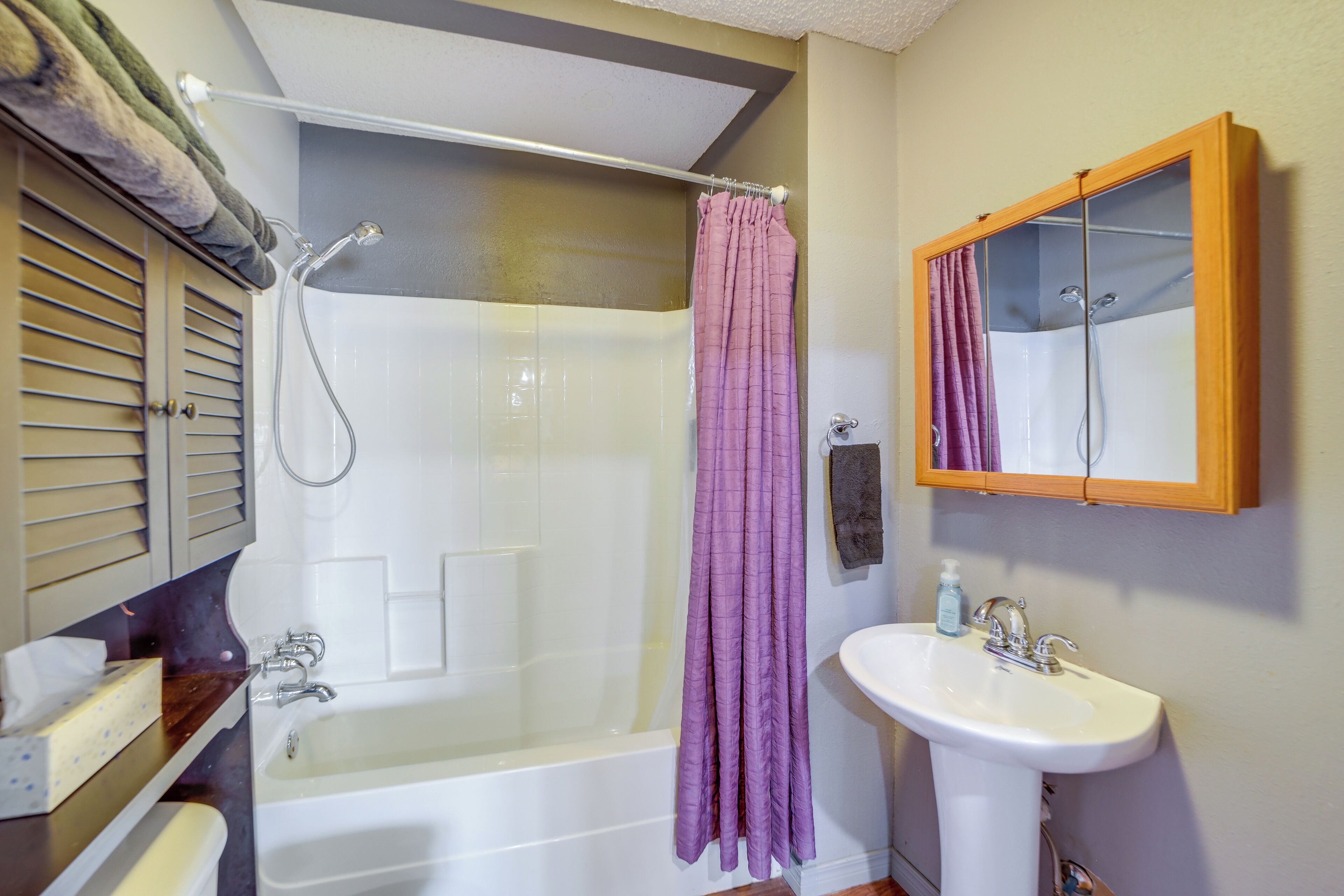 Un baño con bañera, ducha, lavabo y espejo.