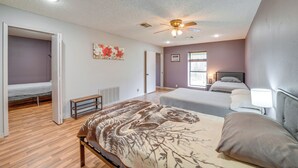 A bedroom with a bed, a ceiling fan, a window, and a door leading to another room. - Outdoorsy Getaway Near Atoka: Hunt, Fish & Relax! (Pittsburg)