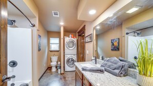 A compact bathroom with a shower, toilet, and washing machine.