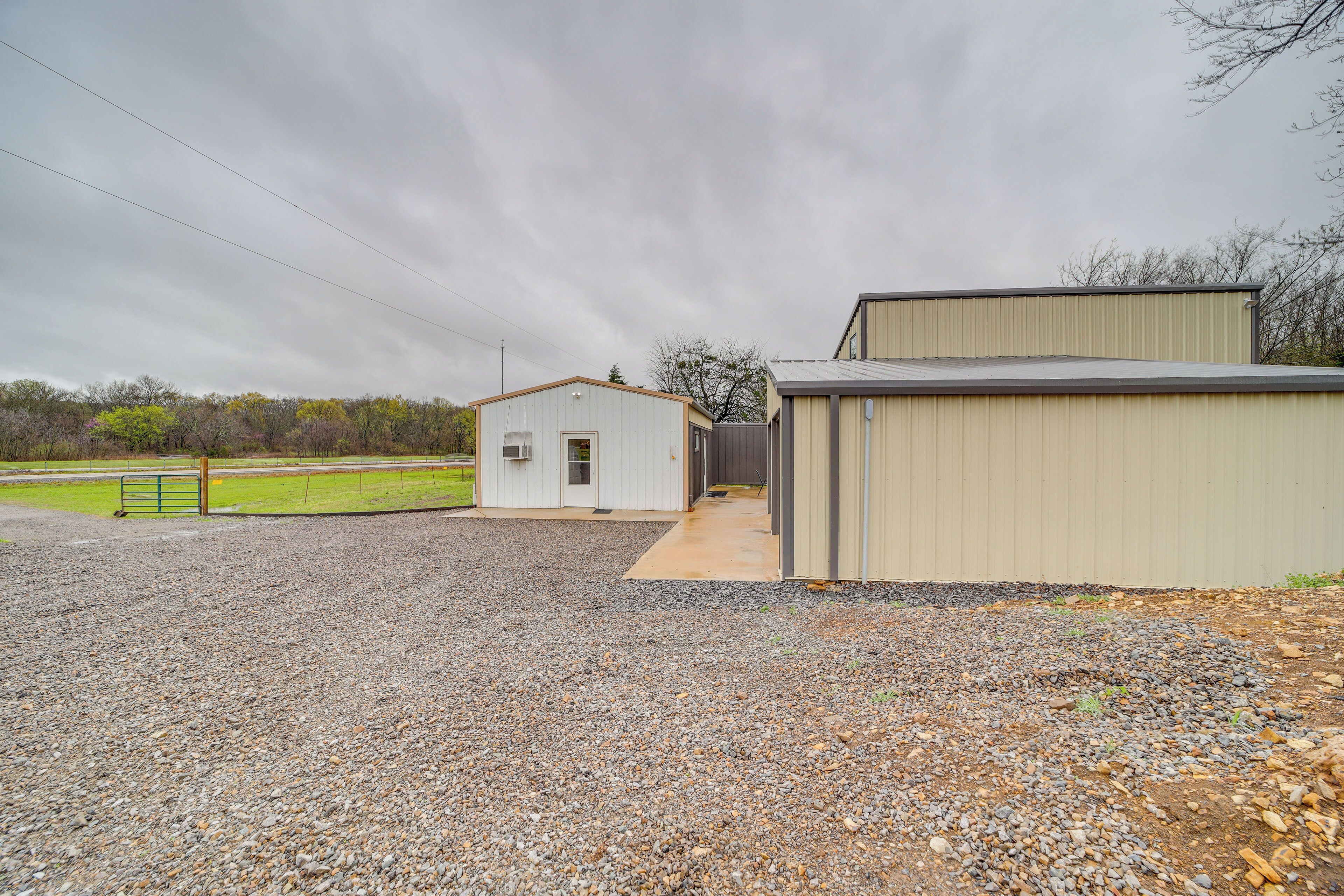 A gravel driveway leading to a building with a small attached garage.