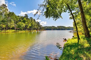 A serene lake surrounded by lush greenery and trees. - Gated Community w/ Perks: North Carolina Hideaway (Connellys Springs)