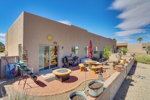 A modern building with a patio area featuring outdoor furniture, a barbecue, and a water feature. - Hot Tub Access & Fire Pit: Green Valley Getaway! (Green Valley)