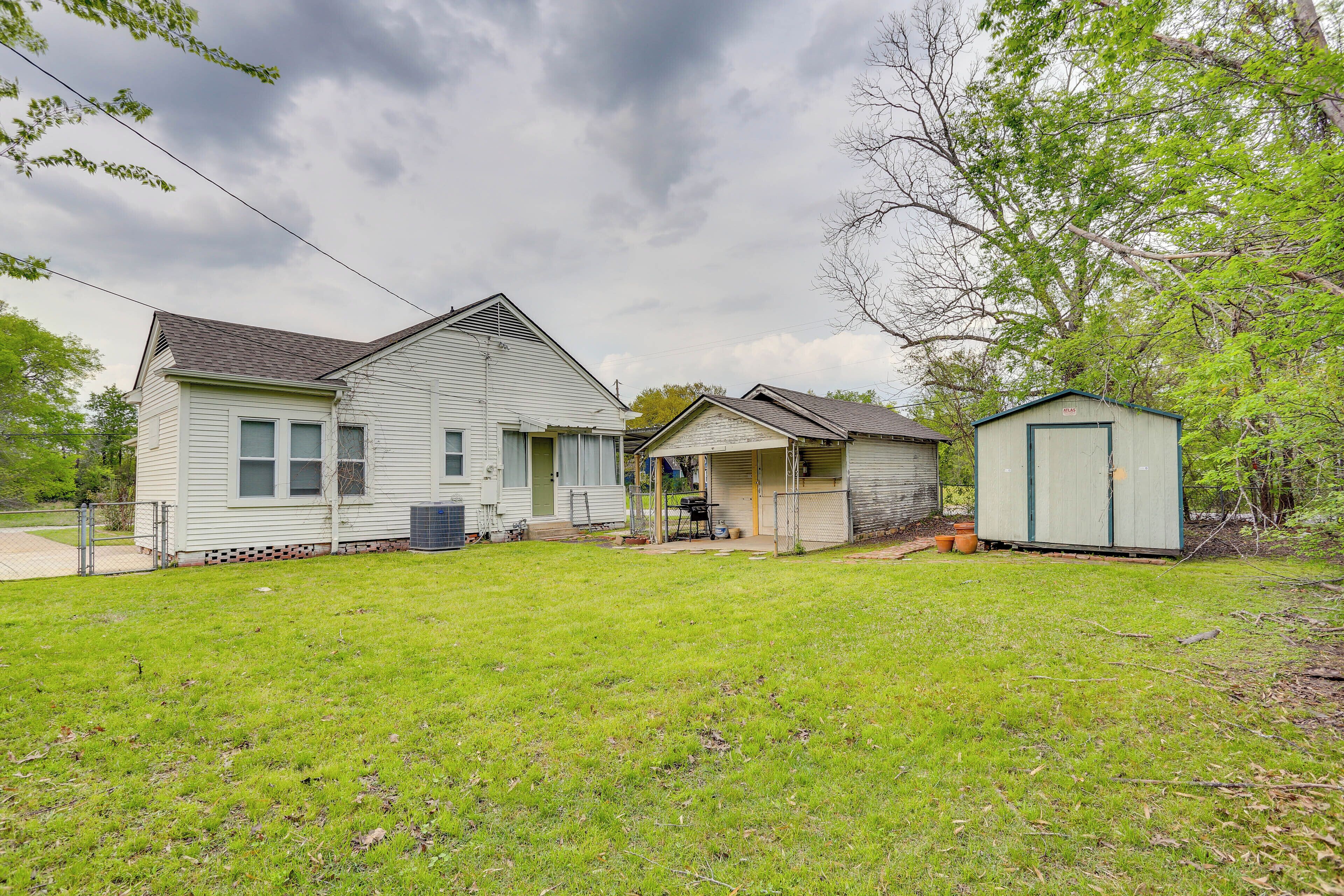 A single-story house with a front porch, a garage, and a small shed.