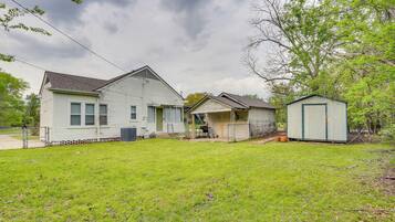 A single-story house with a front porch, a garage, and a small shed.
