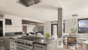 A modern kitchen with a large island, stainless steel appliances, and a view to the living area. - Timberline Lodge by Rove Hot Tub Patio w Views (Snowmass Village)