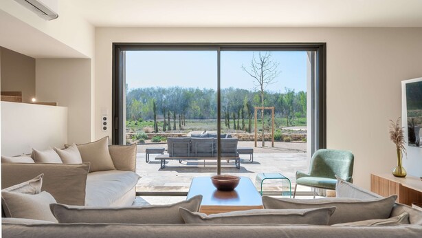 A modern living room with a large window, a sofa, a coffee table, and a chair. - Villa de l Ecluse Maussane les Alpilles (Maussane-les-Alpilles)
