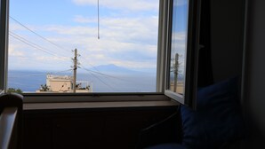 A room with a large window overlooking a coastal view with buildings and power lines. - Cataldo guest house Capri center (Marina Grande)