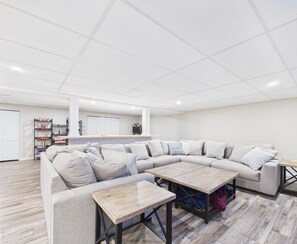 A spacious living room with a large L-shaped sectional sofa, a coffee table, and a side table.