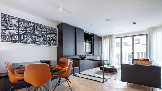 A modern living space with a dining area, kitchen, and seating area. - A pop of colours (London)