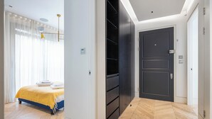 A bedroom with a bed, a wardrobe, and a door. - A pop of colours (London)