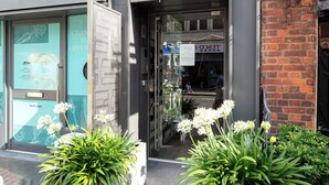 A building with a sign reading "11 Goodge Street" and a storefront with glass windows. - A pop of colours (London)