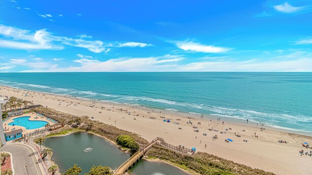 A beach with a pool, clear skies, and a calm sea. - Myrtle Beach Resort RT1103 (Myrtle Beach)