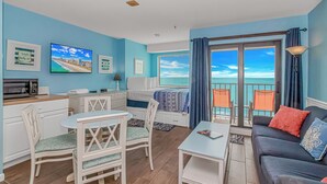 A modern living room with a balcony, a dining area, and a kitchenette. - Myrtle Beach Resort RT1103 (Myrtle Beach)