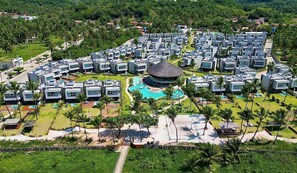 A resort with modern villas arranged around a central pool area, surrounded by lush greenery and palm trees. - Casa Kumari - By Living Milagres (Passo de Camaragibe)