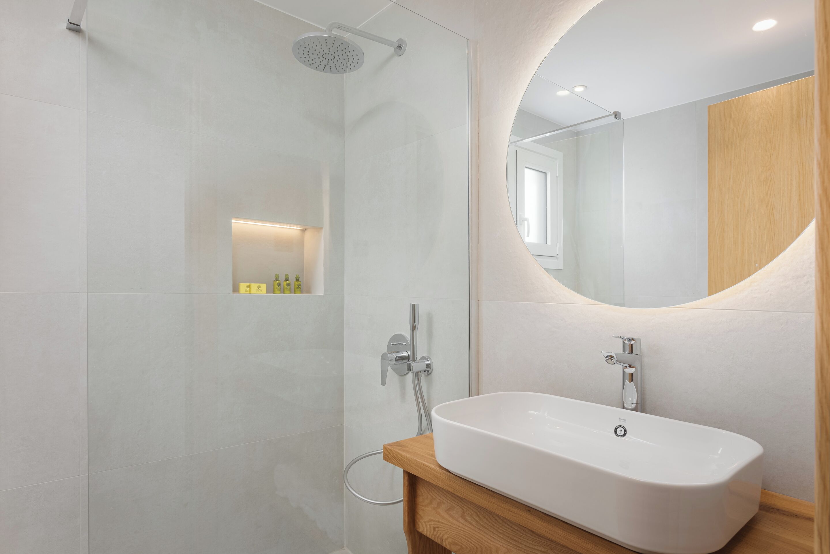 Ein modernes Badezimmer mit einer freistehenden Badewanne, einer gläsernen Dusche und einem Holzbadezimmer-Möbel.