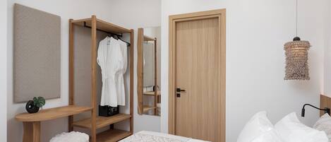 Un dormitorio con cama, armario de madera, espejo y lámpara colgante.