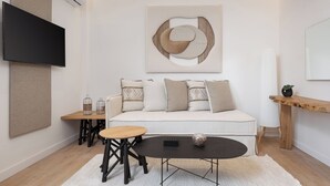 A modern living room with a sofa, coffee table, and decorative items. - Aegina Dream Suites (Aegina)