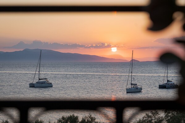 A sunset view of the sea with sailboats.