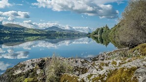 En stilla sjö med en klar spegelbild av himlen och det omgivande landskapet.
