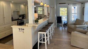 A spacious kitchen with a central island, white cabinetry, and pendant lighting. - GOLDEN OWL - Town of Owls Head (Owls Head)