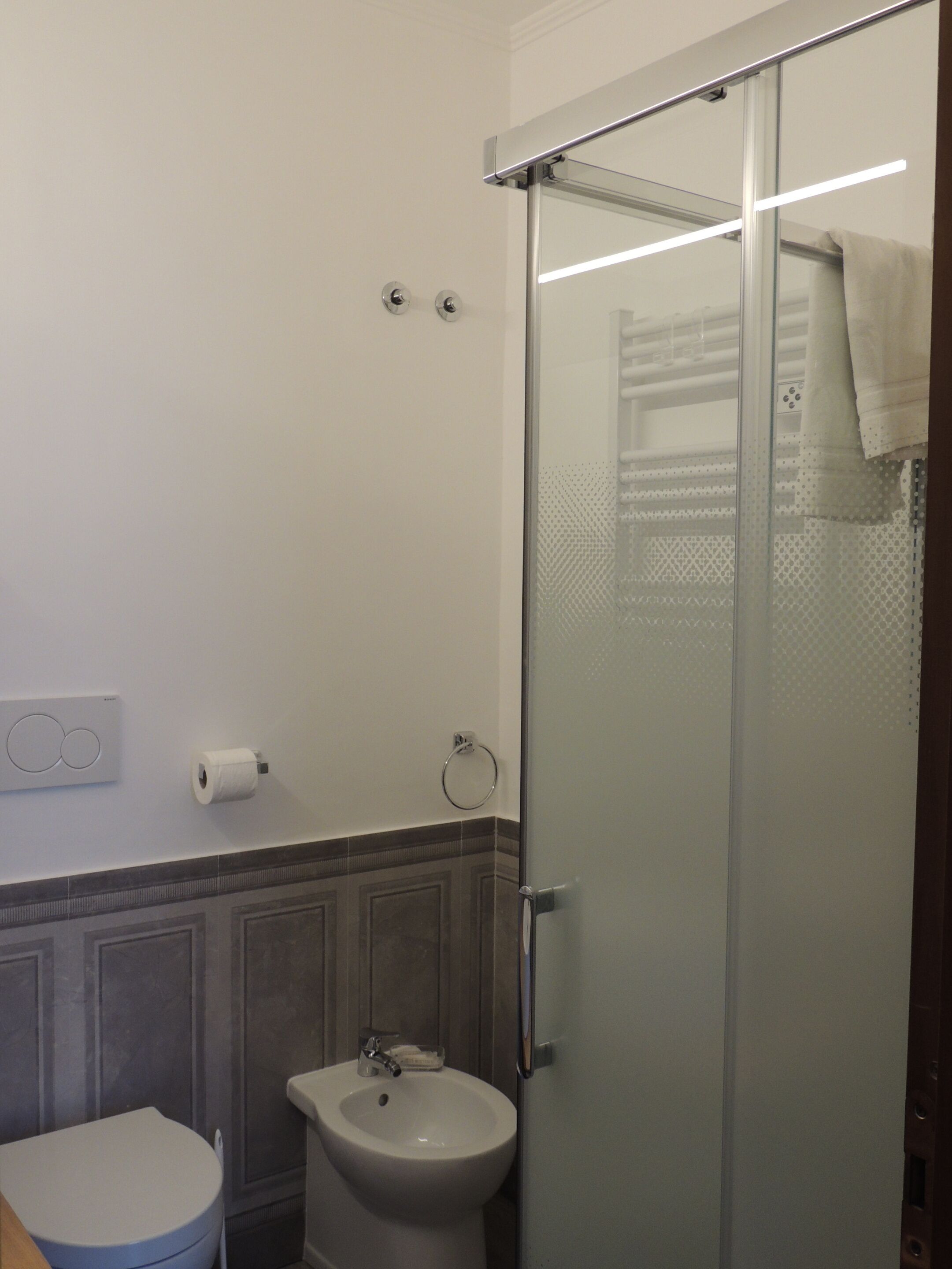 Un bagno con WC, bidet e cabina doccia in vetro.
