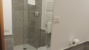 A bathroom with a sink, mirror, shower, and toilet. - Madonna della Neve (Rome)