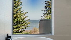 Un baño con vista a una playa y al océano.