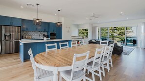 Una cocina moderna con armarios azules, un refrigerador de acero inoxidable y luces colgantes.