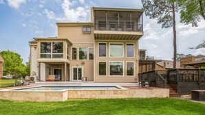 A modern two-story house with a large front yard, a swimming pool, and a deck. - Lakefront Retreat With Private Pool, Hot Tub And Dock 4 Bedroom Home (Montgomery)