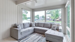 A modern living room with a grey sectional sofa, large windows, and a ceiling fan. - Lakefront Retreat With Private Pool, Hot Tub And Dock 4 Bedroom Home (Montgomery)