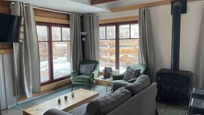 A cozy living room with a fireplace, a sofa, a coffee table, and two armchairs. - Walk to Downtown Creede | Pet-Friendly | Mountain Views | Fenced Yard (Creede)