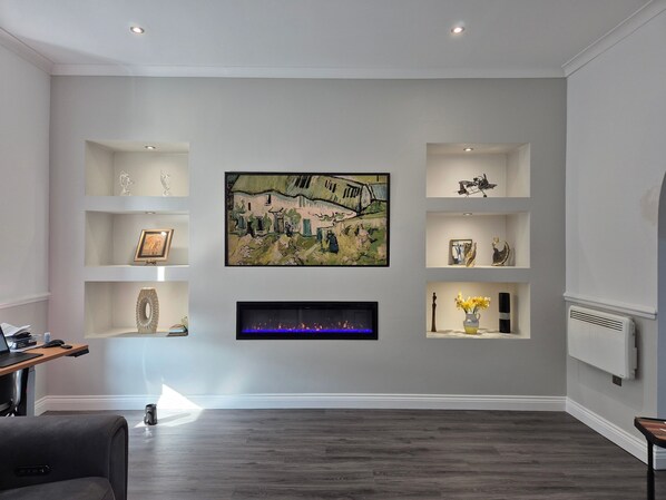 A modern living room with a fireplace, artwork on the wall, and built-in shelving. - 1Br Sheffield Stay - Private, Secure, Free Parking (Sheffield)