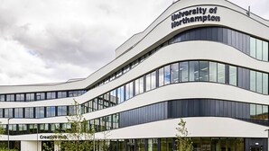 Un edificio moderno con el logotipo de la Universidad de Northampton, que presenta una fachada curva y múltiples ventanas.