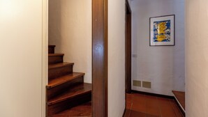 A staircase with wooden steps leading to a landing with a framed artwork on the wall.