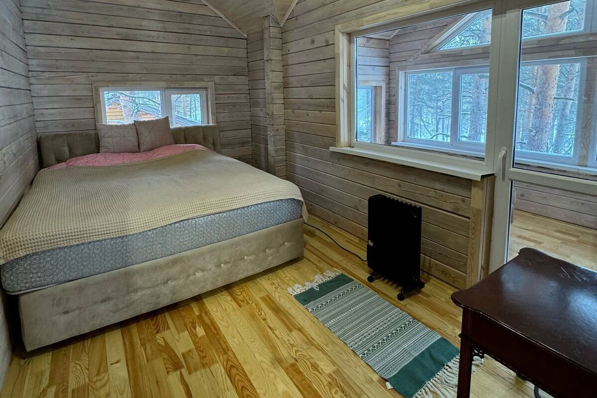 Une chambre à coucher avec un lit, un radiateur et une fenêtre donnant sur des arbres.